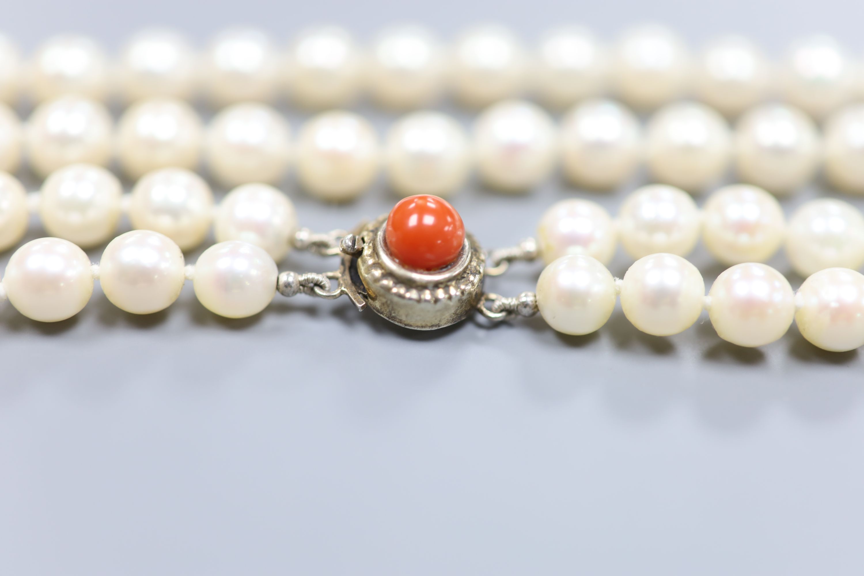 A double strand cultured pearl necklace, with coral bead set 800 white metal clasp, 43cm, gross 51 grams,